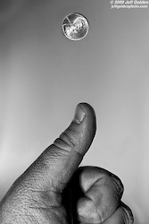 A close up of a hand tossing a coin